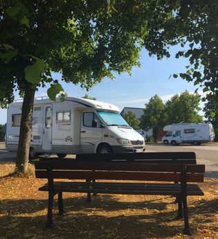 Blick auf eine Bank am Wohnmobilstellplatz P2 in Rothenburg o.d.T., umrahmt von Bäumen. | © Liebliches Taubertal