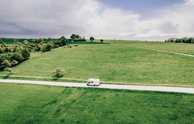Man sieht eine Strasse mit einem weißen Wohnmobil.  Auf beiden Seiten der Strase sind grüne Wiesen. Odenwald. | © Touristikgemeinschaft Odenwald e.V.