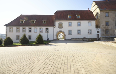 Es sind zwei Gebäudeteile eines Schlosses zu sehen. Davor ein gepflasterter Platz. Ravenstein im Odenwald. | © Touristikgemeinschaft Odenwald e.V.