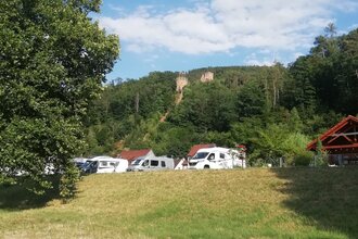 Blick auf den Wohnmobilstellplatz am Stadteingang Süd in Freudenberg am Main. Im Hintergrund ist von Wald umgeben die Freudenburg zu sehen. | © Liebliches Taubertal