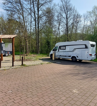 Ein gepflasterter Platz mit zwei weißen Wohnmobilen. Im Hintergrund ist eine Informationstafel. Mosbach im Odenwald. | © Stadt Mosbach