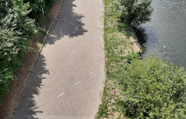 Blick auf einen Parkplatz von oben. Auf der rechten Seite ist ein Fluß. Zwingenberg im Odenwald.