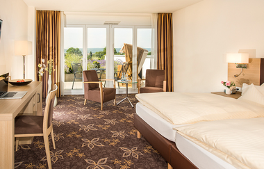 Im Zimmer steht ein Doppelbett, eine Sitzgruppe, ein Schreibtisch und ein TV | © Touristikgemeinschaft Hohenlohe e. V. | Hotel Württemberger Hof