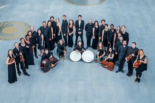 Eine Gruppe von Musikern in schwarzer Kleidung steht in einem Kreis auf einem grauen Boden. | © Kulturstiftung Hohenlohe