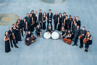 Eine Gruppe von Musikern in schwarzer Kleidung steht in einem Kreis auf einem grauen Boden. | © Kulturstiftung Hohenlohe