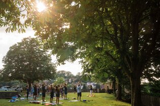 Yogis beim Praktizieren auf der Wiese | © Pranaphyio Jeanette Stapf
