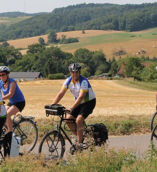 Radlergruppe auf einem Fahrradweg im Hintergrund Felder und Bäume | © Touristikgemeinschaft Odenwald e.V.