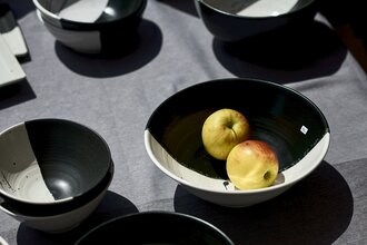 Schwarz-Weiße Schalen stehen auf einem Tisch. In einer Schale befinden sich zwei Äpfel. | © Touristikgemeinschaft Hohenlohe e.V. | Stefan Leitner