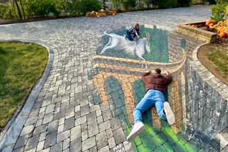 Zwei Personen interagieren mit einer 3D-Straßenmalerei, die eine Brücke und ein Einhorn darstellt. | © Erlebnispark Tripsdrill