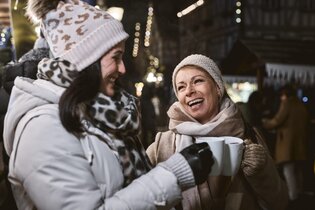 Lachende Menschen auf dem Weihnachtsmarkt