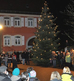 Menschen beim Singen auf dem beleuchteten Marktplatz