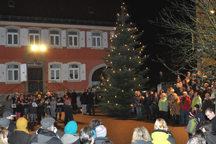 Menschen beim Singen auf dem beleuchteten Marktplatz