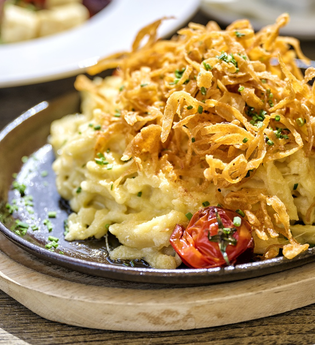 Ein Teller Käsespätzle mit Röstzwiebeln | © Tourimia Tourismus GmbH | Florian Trykowski