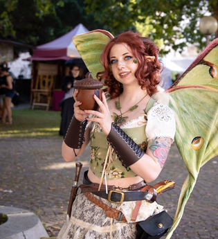 Eine Frau verkleidet als Fee oder Elfe, die Flügel sind grün. | © Philip Drost