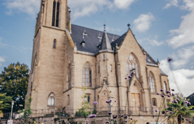 Stadtkirche frontal mit Blumen im Vordergrund | © Stadt Bad Rappenau I Chris Frumolt
