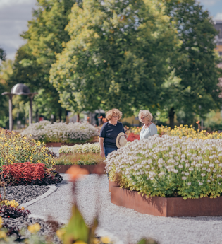 Spaziergänger am Feuerbeet inmitten von Blumenbeeten I Bad Rappenau I HeilbronnerLand | © Stadt Bad Rappenau I Chris Frumolt