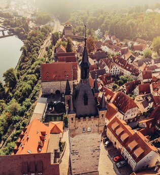 Luftbild von der Altstadt Bad Wimpfen. Links unterhalb ist der Neckar mit seinem Verlauf im Tal zu sehen. Zentrales Bildelement ist der "Blaue Turm" von oben". | © Stadt Bad Wimpfen