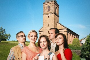 5 Schauspieler stehen vor einer Kirche