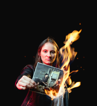 Junge Schauspielerin hält ein brennendes Foto in der Hand
