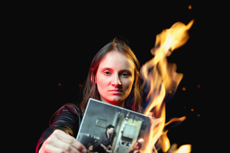 Junge Schauspielerin hält ein brennendes Foto in der Hand