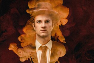 Der Schauspieler steht im Nebel und blickt stur in die Kamera