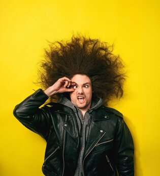Der Schauspieler blickt in die Kamera und reißt die Augen auf.