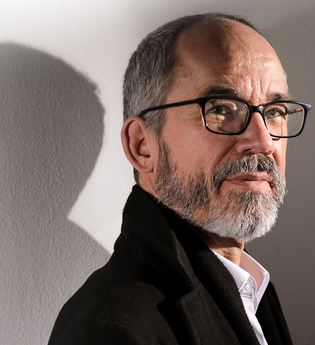 Portrait des Künstlers vor einer Wand. die seinen Schatten wirft