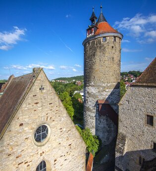 Historische Gebäude in Besigheim mit einem Turm und alten Steinhäusern unter blauem Himmel. | © Stadt Besigheim