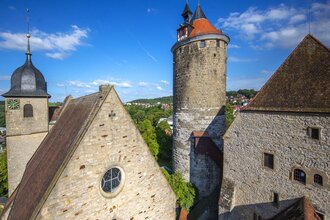 Historische Gebäude in Besigheim mit einem Turm und alten Steinhäusern unter blauem Himmel. | © Stadt Besigheim