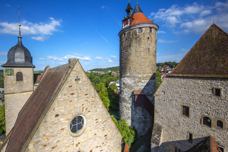 Historische Gebäude in Besigheim mit einem Turm und alten Steinhäusern unter blauem Himmel. | © Stadt Besigheim