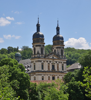 Blick auf die Klosterkirche Schöntal umgeben von grünen Bäumen | © Touristikgemeinschaft Hohenlohe e.V. | Andi Schmid