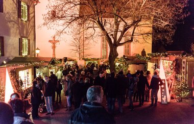 Beleuchteter Kunsthandwerkermarkt auf dem Kirchplatz
