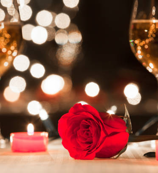 Ein Tisch mit zwei Glas Wein, Kerzen, einer Rose sowie Lichtern im Hintergrund | © Touristikgemeinschaft Hohenlohe e. V. | Michael Wendler, Hoftheater Öhringen