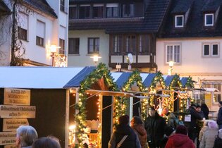 Blick auf den Weihnachtsmarkt mit geschmückten Weihnachtsbäumen und Weihnachtsbaumhütten