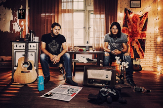 Zwei Männer sitzen in einem Raum mit Musikinstrumenten und Dekorationen. | © Kulturfenster Bönnigheim e. V.