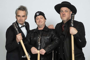 Drei Männer mit Mikrofonen posieren in Anzügen und Lederjacke. | © C² CONCERTS GmbH