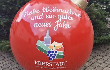 Christbaumkugel vor dem Weihnachtsbaum