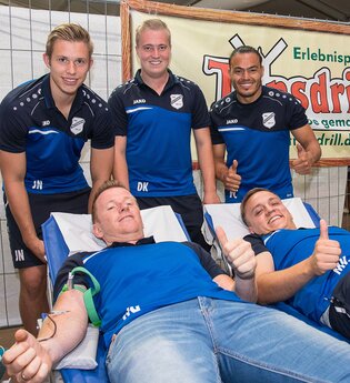 Zwei Männer liegen auf Liegen und spenden Blut, während drei weitere Männer daneben stehen und Daumen hoch zeigen. | © Erlebnispark Tripsdrill