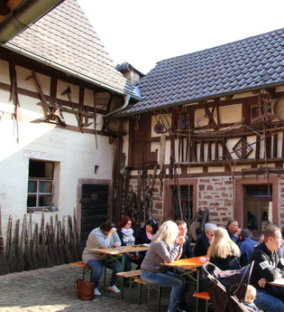 Leute sitzen an Bierbanken vor einem Fachwerkhaus | © Landratsamt Rhein-Neckar-Kreis