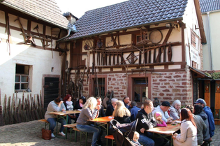 Leute sitzen an Bierbanken vor einem Fachwerkhaus | © Landratsamt Rhein-Neckar-Kreis