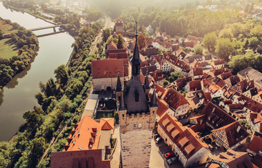 Luftbild von der Altstadt Bad Wimpfen. Links unterhalb ist der Neckar mit seinem Verlauf im Tal zu sehen. Zentrales Bildelement ist der "Blaue Turm" von oben". | © Stadt Bad Wimpfen