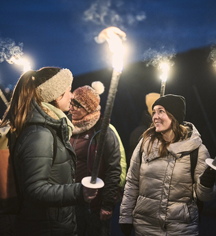 Eine Gruppe mit brennenden Fackeln bei einer Führung im dunkeln | © Tourimia Tourismus GmbH I Stefan Leitner