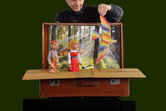 Bühnenkulisse mit Spielfiguren, im Hintergrund der Künstler | © Figurenthater Fex