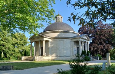 Frasch Mausoleum - Rotunde aus hellem Stein mit dunkelgrauer Kuppel und Laterne, zwei Portikus mit je vier Säulen, umgeben von Rasen und Bäumen | © Petra Natzkowksi