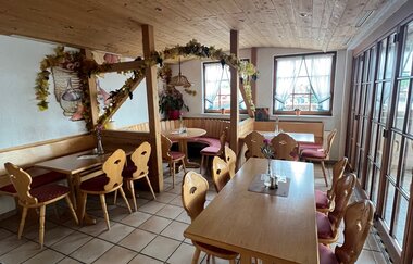 gemütlicher Gastraum mit einige Holzstühlen und Holztischen im Weingut Härle | © Weingut Härle