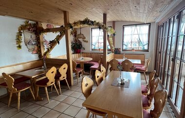 gemütlicher Gastraum mit einige Holzstühlen und Holztischen im Weingut Härle | © Weingut Härle
