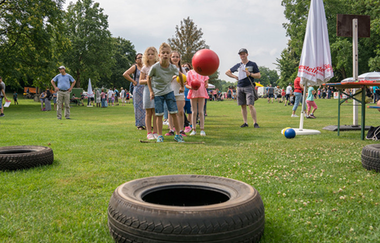 Spielstation für Kinder. Autoreifen im Vordergrund. Gruppe von Kindern wirft einen Ball in den Reifen. | © Heilbronn Marketing GmbH