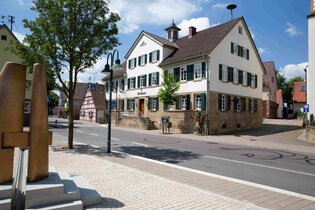 Außenansicht eines historischen Dorfhauses mit einer Dorfstraße im Vordergrund. | © Stadt Brackenheim