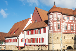 altes Schloss - rechts das Torhaus mit Sockelgeschoss aus hellem Sandstein und aufgesetztem roten Fachwerk mit weißen Gefachen, flankiert von zwei Rundtürmen. In der Bildmitte der Westflügel mit zwei aneinandergebauten, weiß verputzten Gebäudeteilen mit r | © Stadt Gaildorf