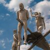 Am Ortseingang von Lauffen am Neckar erhebt sich das eindrucksvolle Kunstwerk „Hölderlin im Kreisverkehr“ des Bildhauers Peter Lenk. Auf einem geschwungenen „H“ balanciert eine überdimensionale Schreibfeder, auf der Friedrich Hölderlin als Kind und als ju